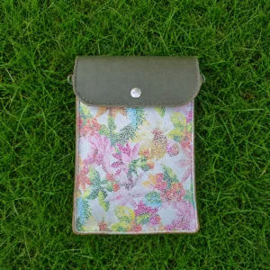 Pochette artisanale en cuir vert kaki et blanc à motifs fleuris colorés, portée en bandoulière.